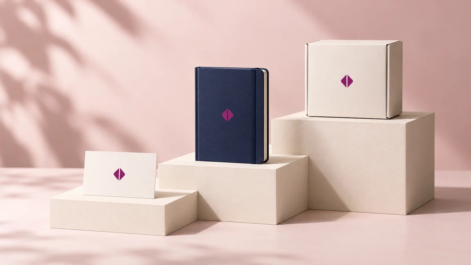 Three stages of a brand kit, arranged on stepped studio plinths.